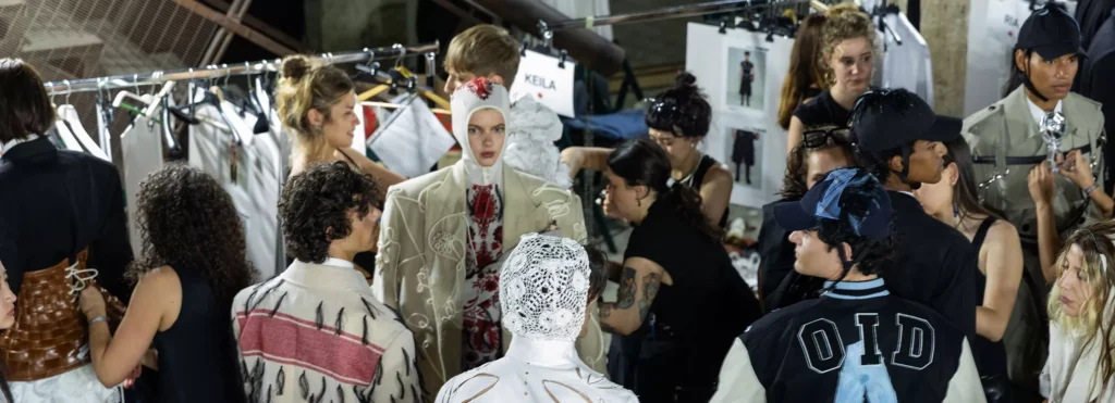 A dynamic and high-energy fashion show backstage managed by students during an Event Production workshop.