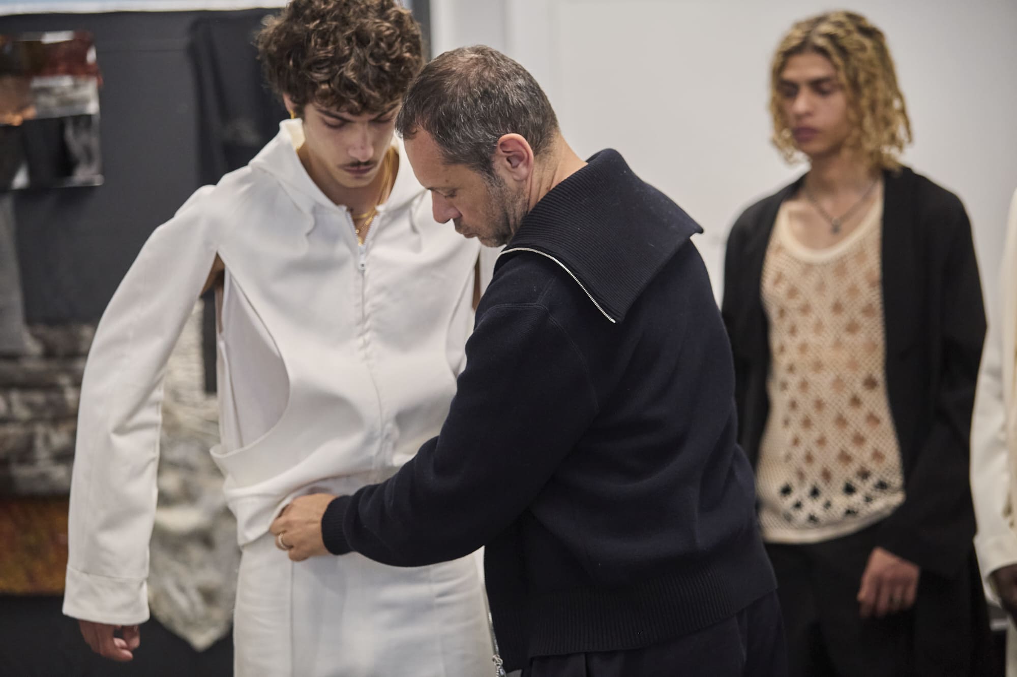 Massimiliano Giornetti examining a student-made garment prototype during Fashion Design collection reviews at Polimoda.