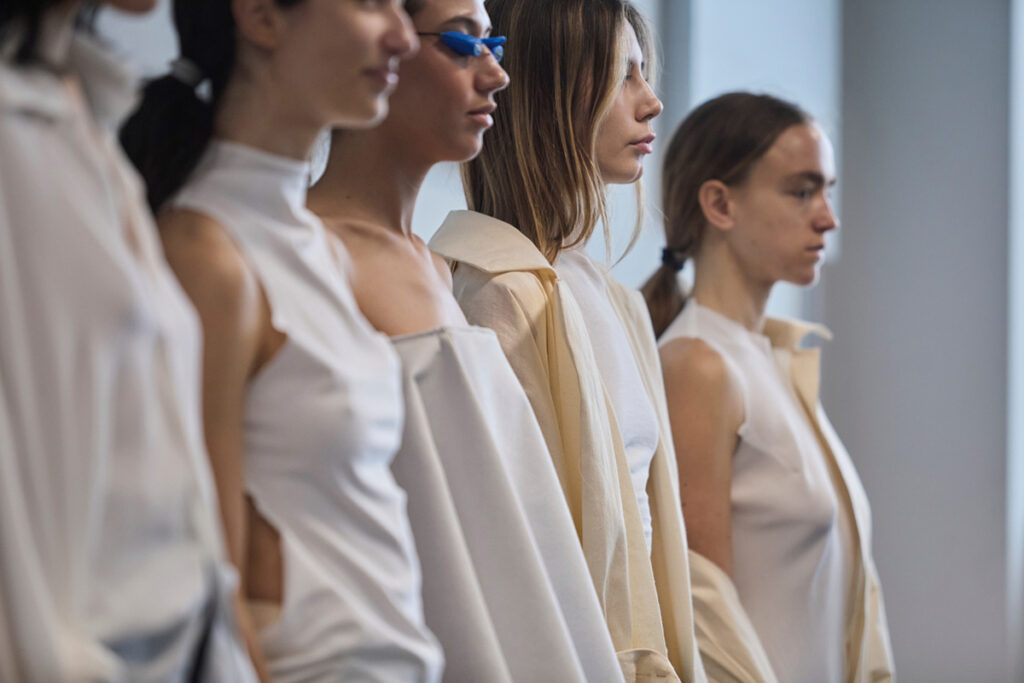 Students wearing monochromatic prototype garments during final collection reviews at Polimoda’s Manifattura Campus.